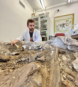 Student Ben Rotenberg with dinosaur fossil.