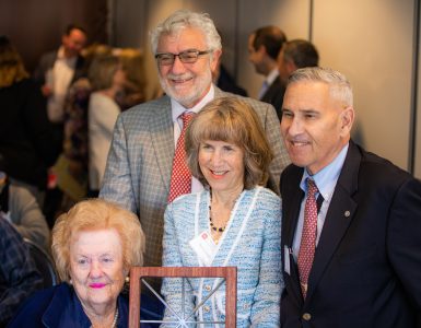 Sandy Fainbarg, left, with Nancy and Irv Chase and President Struppa pose for a photo holding a gift of a Chapman window sculpture.