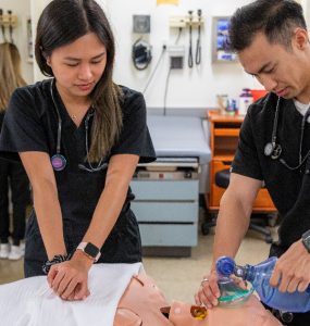 Two physician assistant students work on a "patient."
