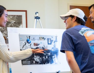 Attendees look at student art at Fowler School of Law's climate conference
