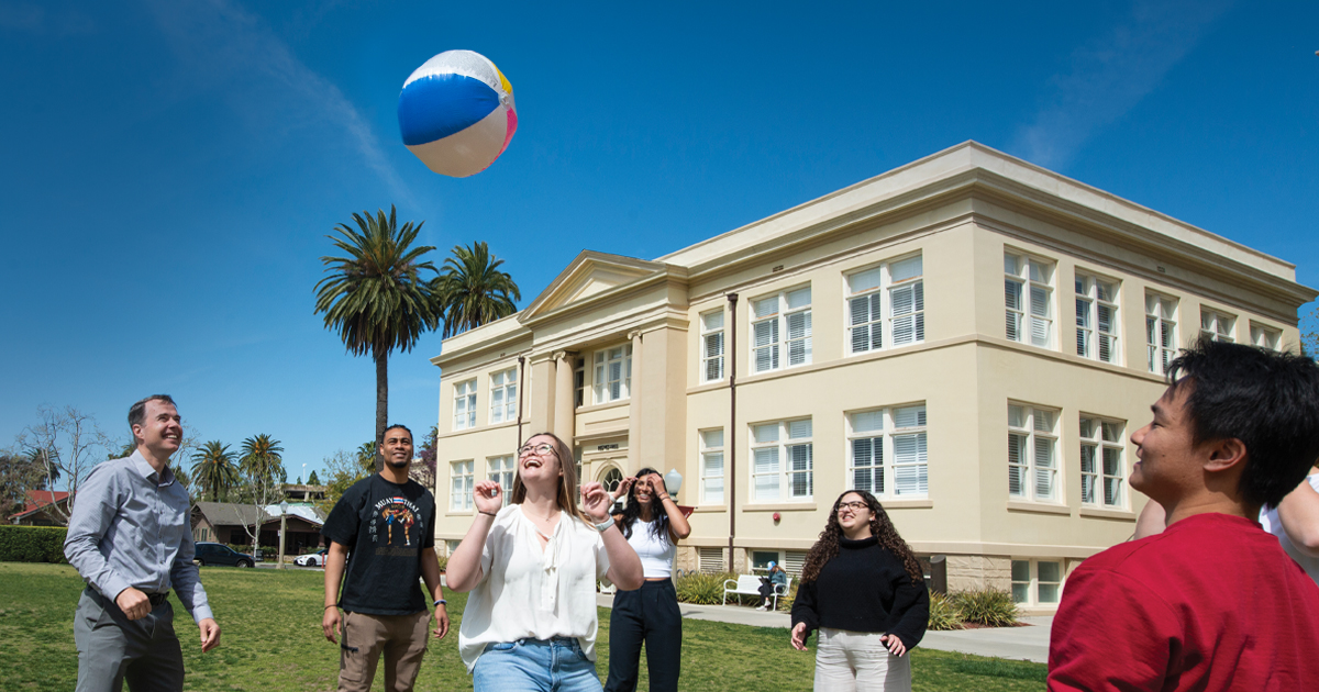 group of students hit a beachball in the air on chapman's memorial lawn