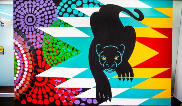 a mural panel with bright colored designs and a black panther
