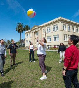 group of students hit a beachball in the air on chapman's memorial lawn
