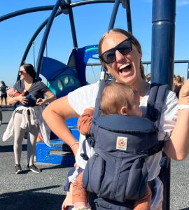stephanie morrison at beach playground with baby in front carrier