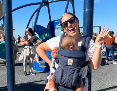stephanie morrison at beach playground with baby in front carrier