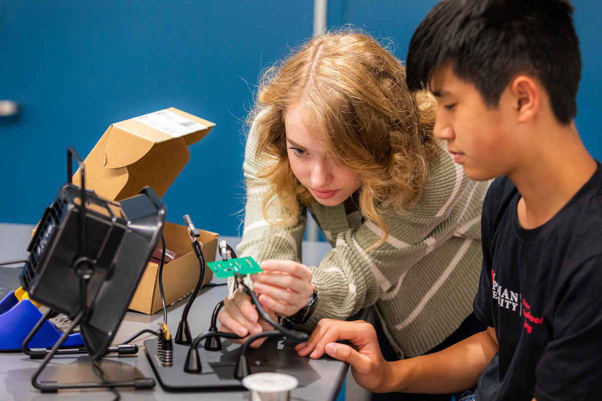 students soldering on circuit board