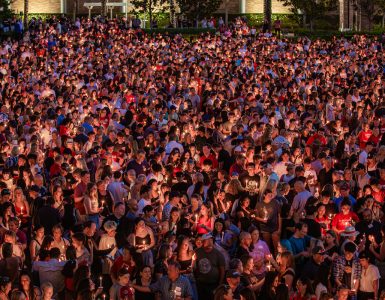 crowd with candles at sunset