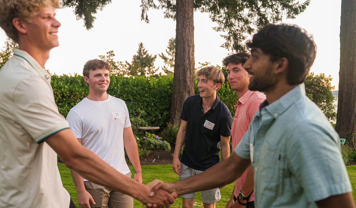 young alumni and students shaking hands