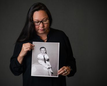stephanie takaragawa holding black and white portrait of young boy