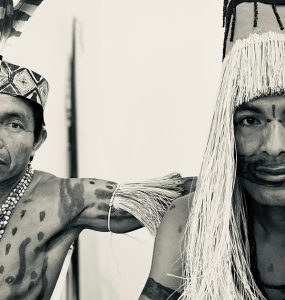 black and white photo of Amahuaca men in traditional garb