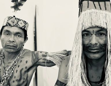 black and white photo of Amahuaca men in traditional garb