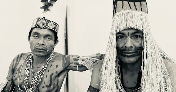 black and white photo of Amahuaca men in traditional garb