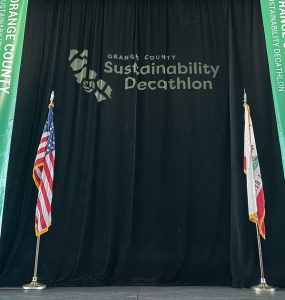 stage with black curtain that reads sustainability decathalon