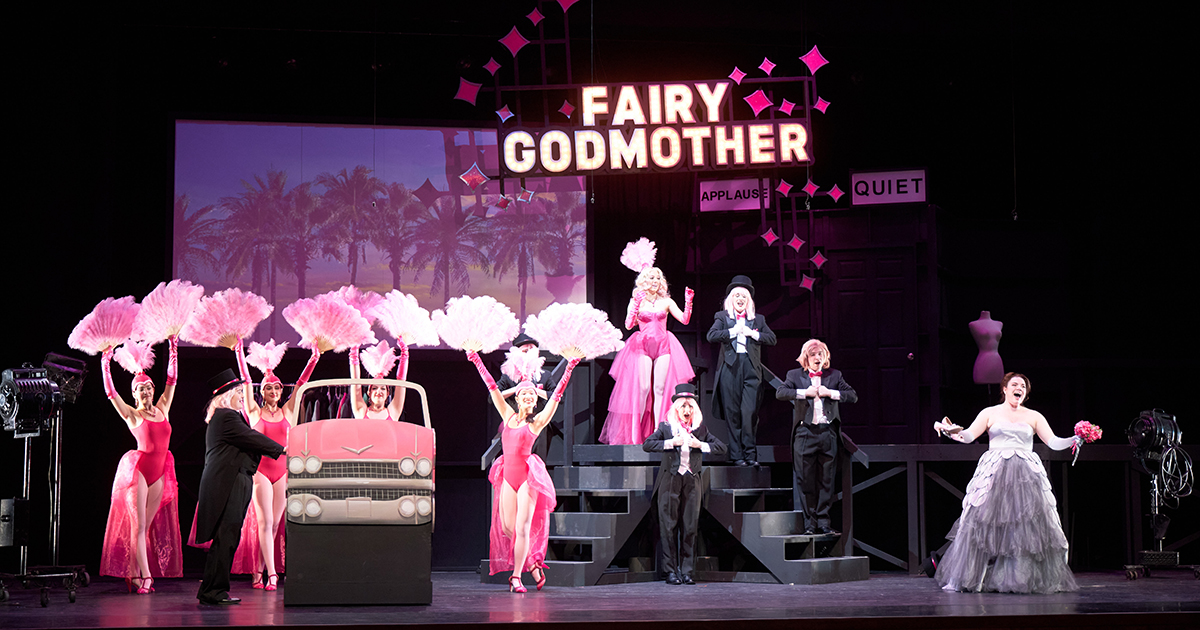 opera production with chorus girls and "fairy godmother' in neon lights