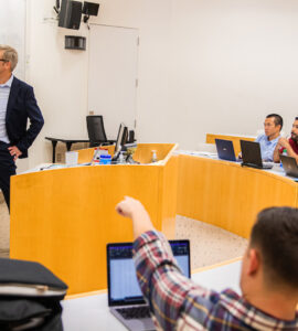 professor pointing at whiteboard in classroom
