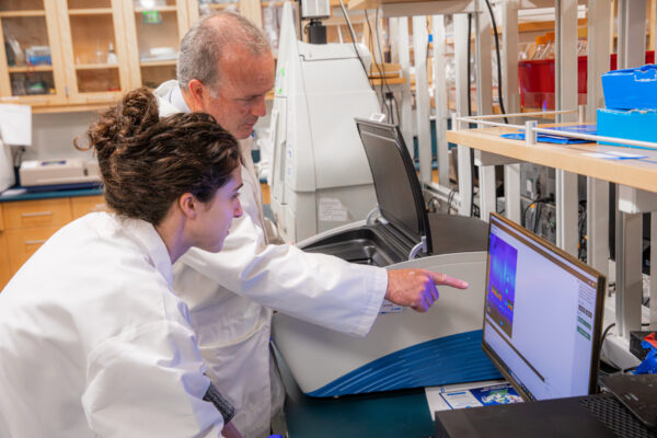 Chapman School of Pharmacy Dean Rennolds Ostrom works with a student in his lab.