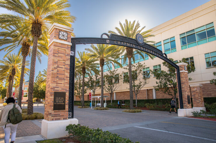 wrought iron gate with words Chapman University leading into college campus