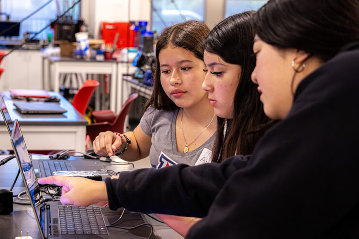 Three girls looking at computer screen