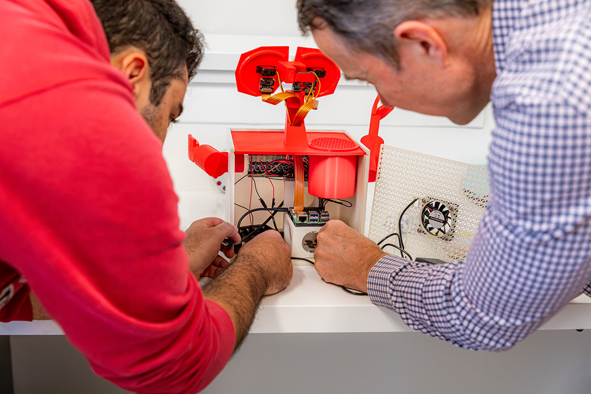 two team members working on wiring a camera