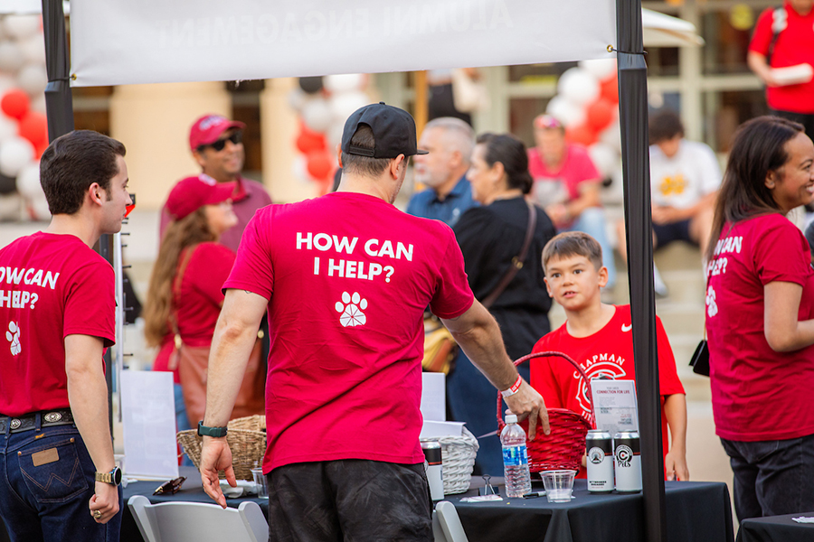 rear view of volunteers wearing shirts that say How Can I Help?