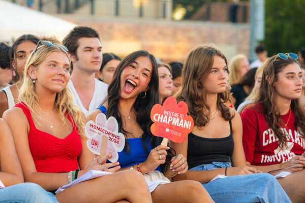 girls in stadium holding welcome to chapman signs