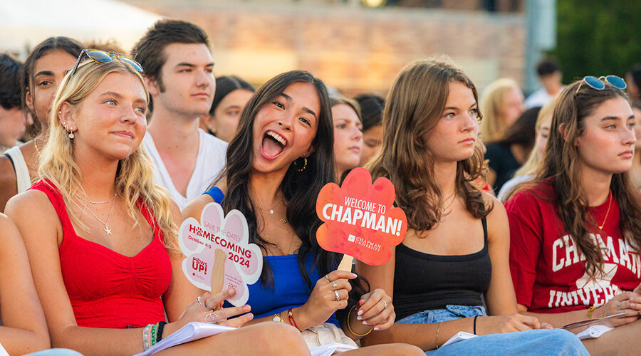 girls in stadium holding welcome to chapman signs