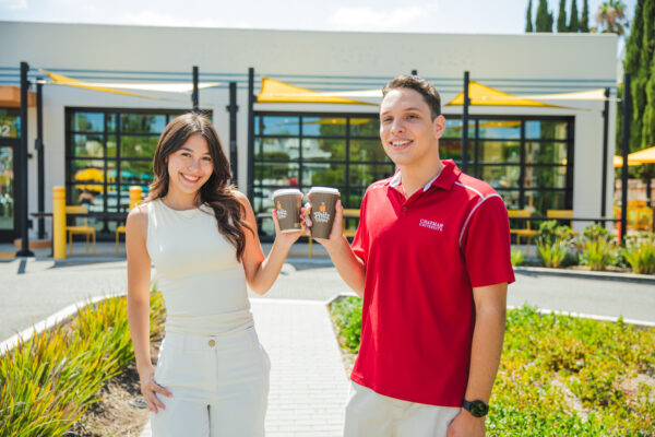 Two students posing with coffee cups