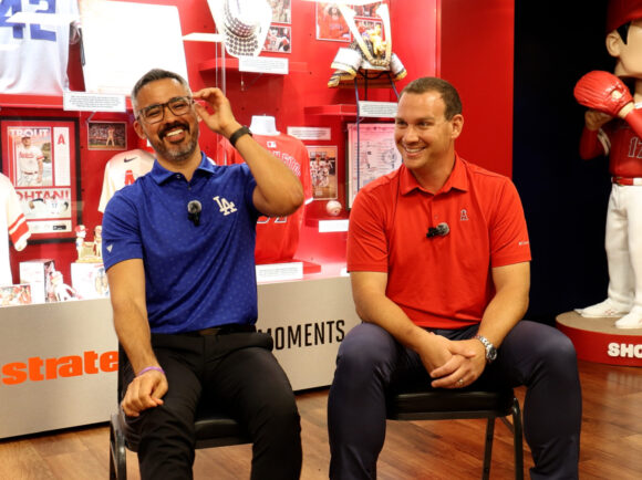 Stephen Nelson (left) and Trent Rush (right) sit for an interview in front of a commemorative case of Angels memorabilia.