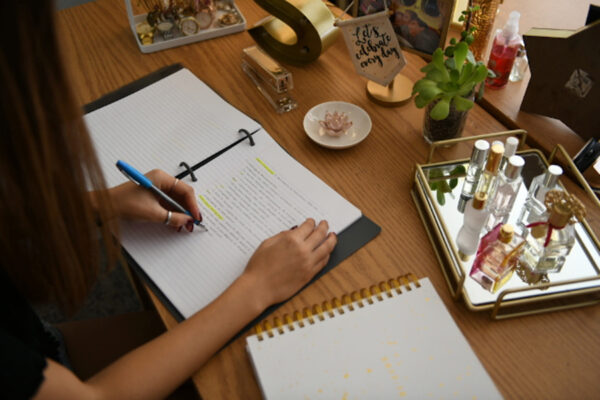 woman writing in open notebook