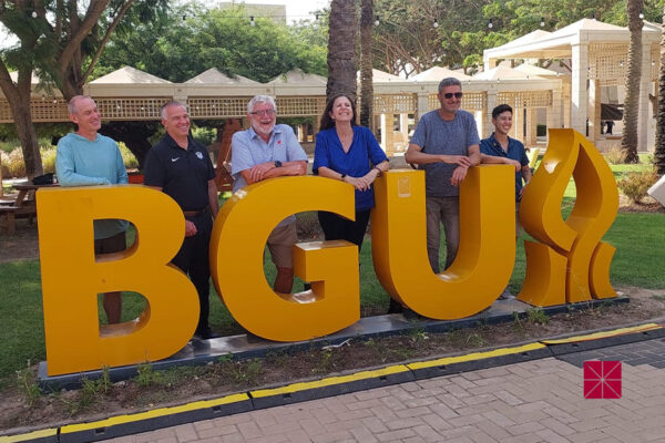 guys aroundd BGU sign