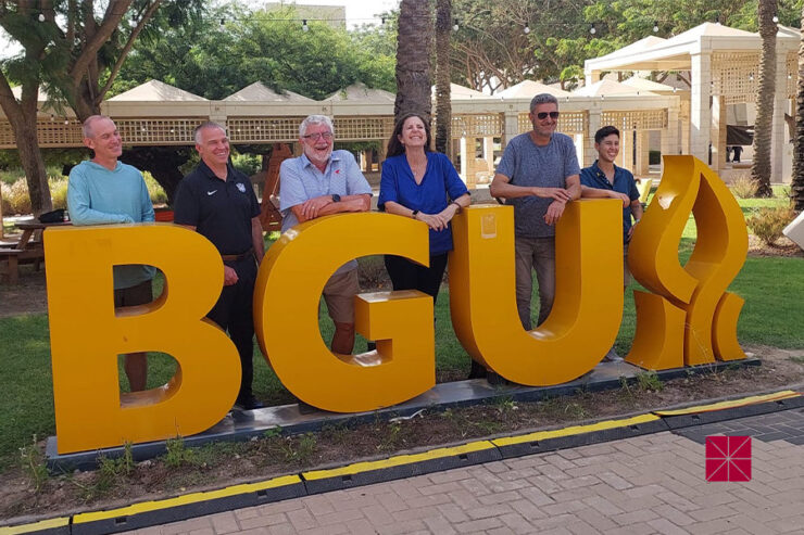 guys aroundd BGU sign