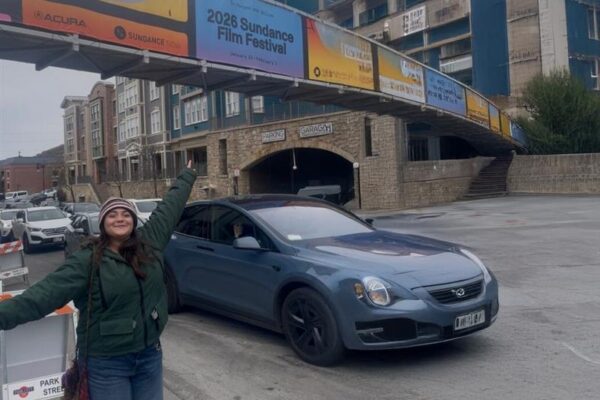 Paige Filipan posing with the Sundance bridge banner on Main Street.