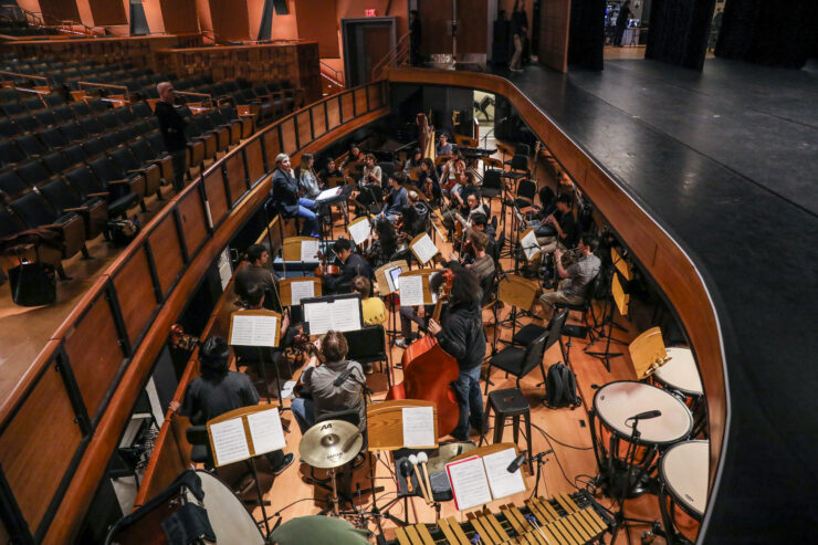 Student musicians sit in the orchestra pit at Musco Center, led by conductor Danko Druško, Ph.D., as they perform during a live dance production.