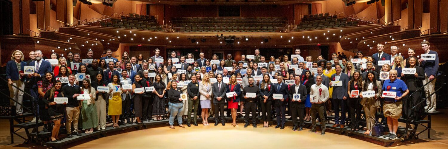 A large group of employer representatives pose for a photo onstage inside Musco Center for the Arts following a recognition ceremony at the State of the University.