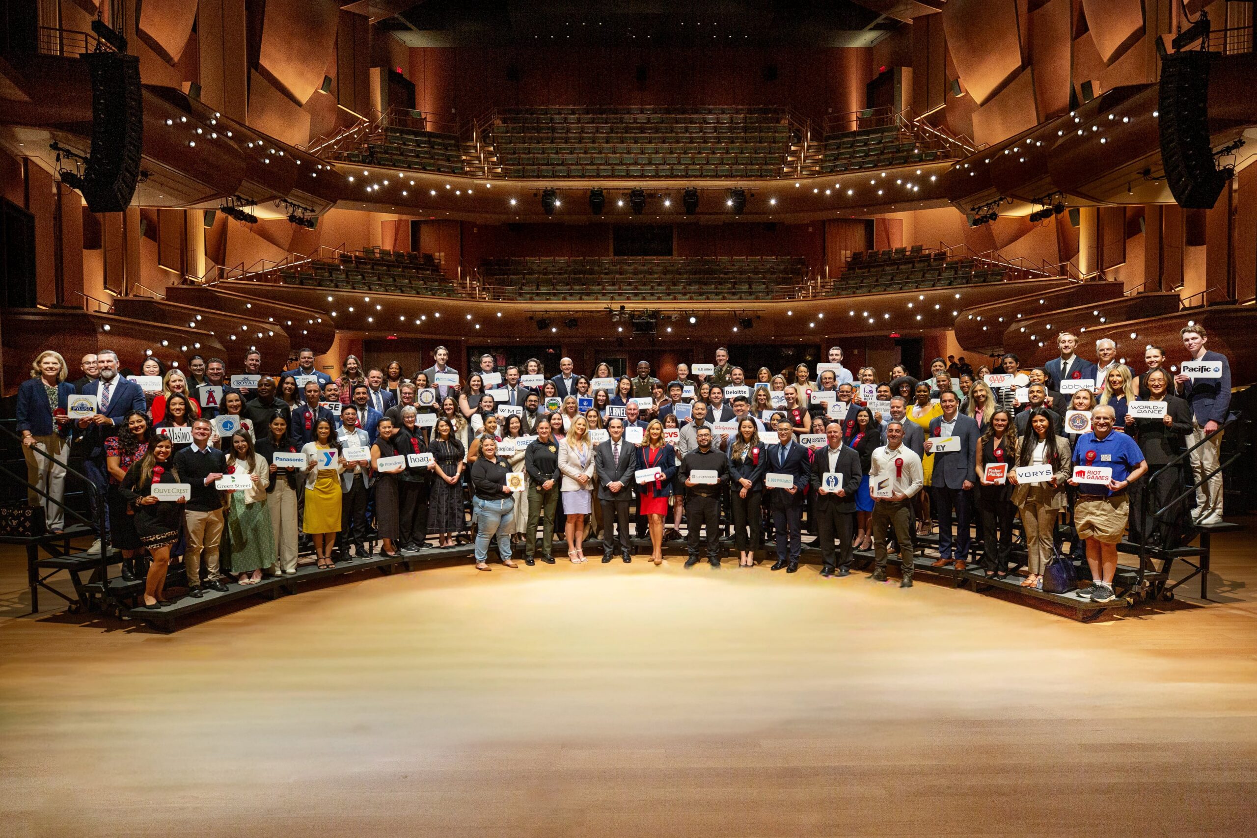 A large group of employer representatives pose for a photo onstage inside Musco Center for the Arts following a recognition ceremony at the State of the University.