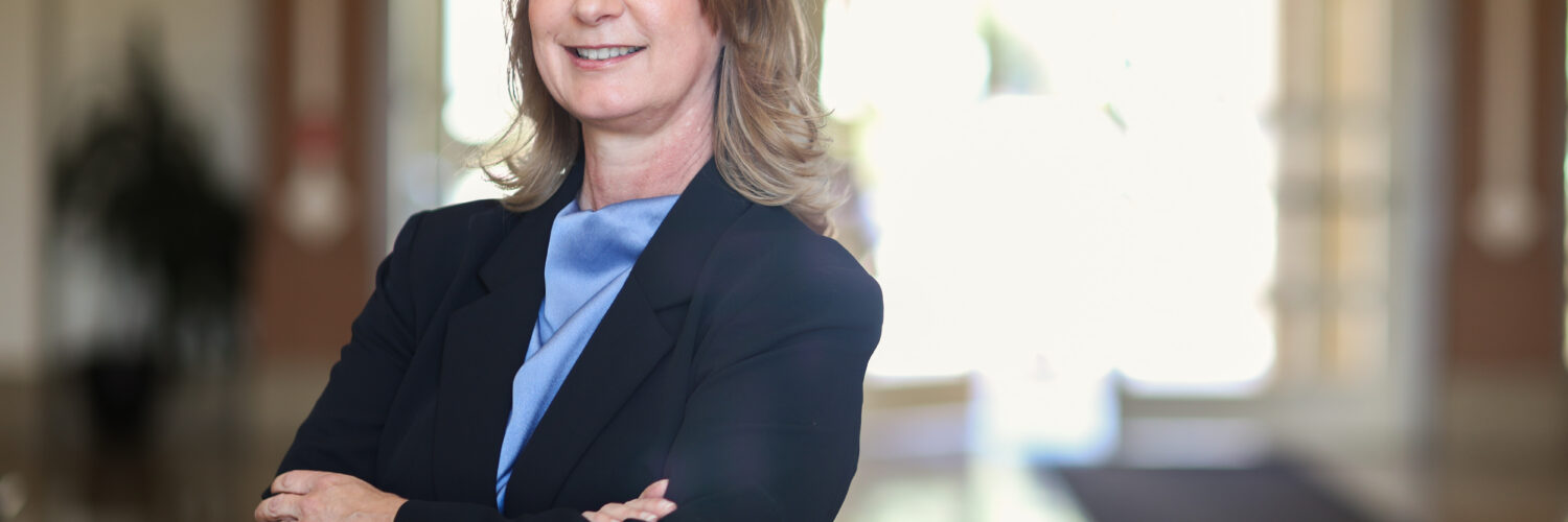 Tara Gruenewald stands in the lobby of a building.