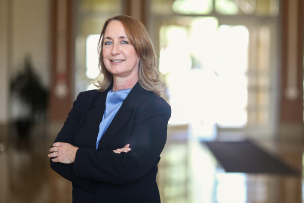 Tara Gruenewald stands in the lobby of a building.