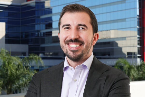 Adam Kalawi smiling with arms crossed in front of CHOC Children’s Hospital building in Orange, California.