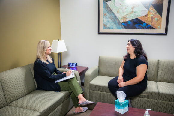 Two women sit for a counseling session within the MFT program. An example of what you can do with a Psychology degree.