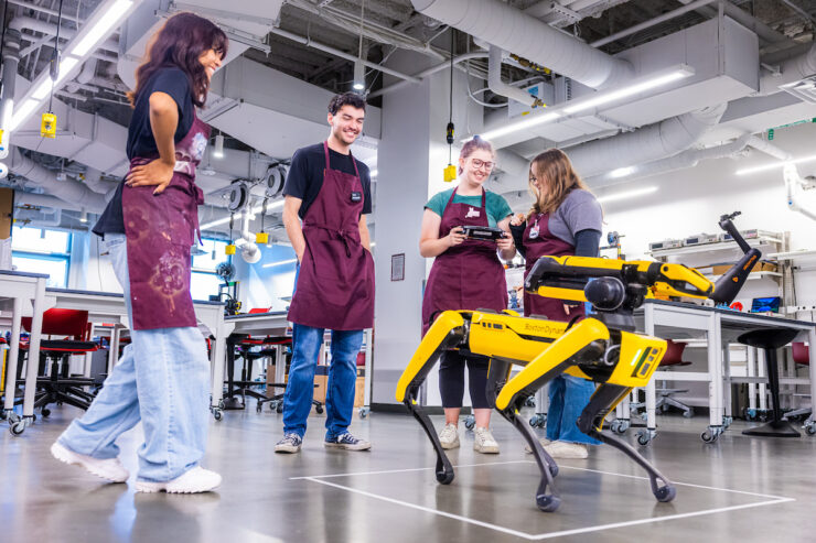 four engineers working with a robotic dog