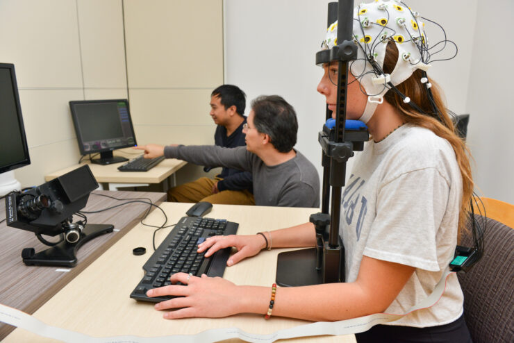 Students review data and research alongside their professor, deepening their understanding of the human brain.