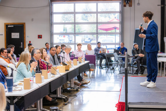 MBA student presenting a business strategy project to a large audience during a classroom presentation