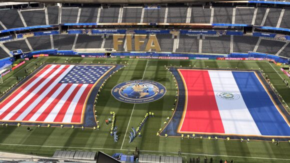Images of the United States and Paraguay flags are on the field at SoFi Statdium