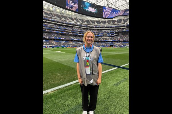 Lisa Pressler smiles beside the field at SoFi Stadium during the FIFA World Cup.