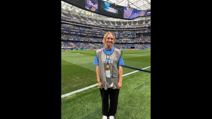 Lisa Pressler smiles beside the field at SoFi Stadium during the FIFA World Cup.