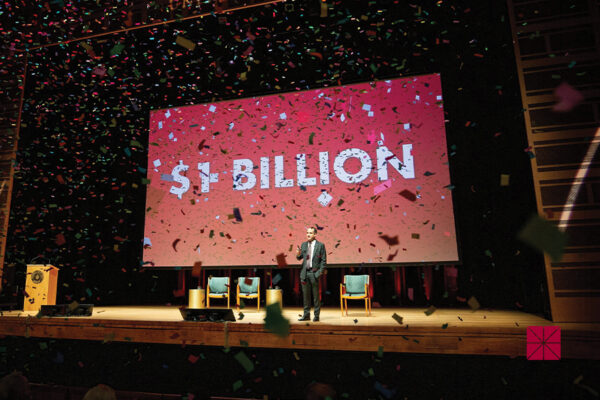 Chapman University President Matt Parlow stands on stage at Musco Center for the Arts as confetti falls in celebration of Chapman's endowment reaching $1 billioin.