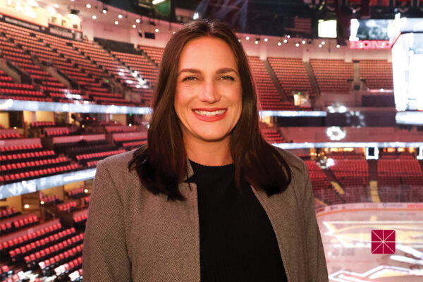 Lauren Fitzpatrick (J.D. ‘18) stands in the Honda Center with the hockey rink behind her.