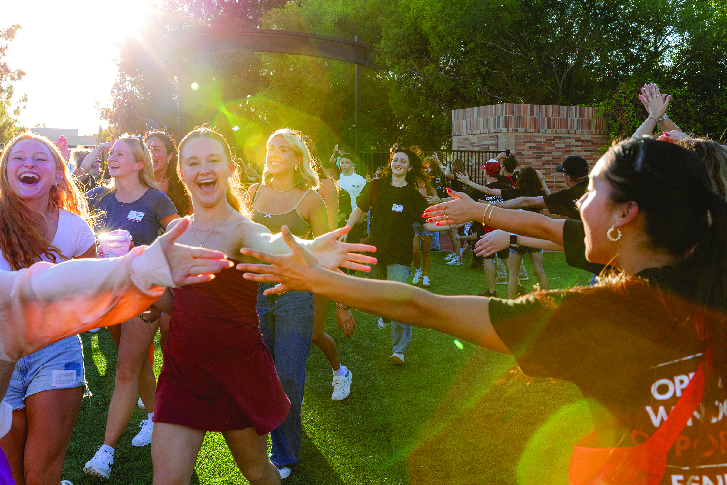 Students high-five orientation counselors as they enter Wilson Field for Opening Convocation.