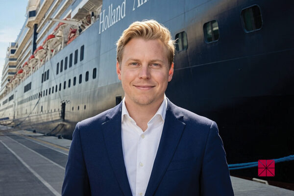 oe Chantry stands on a dock in front of a Holland America Line cruise ship.