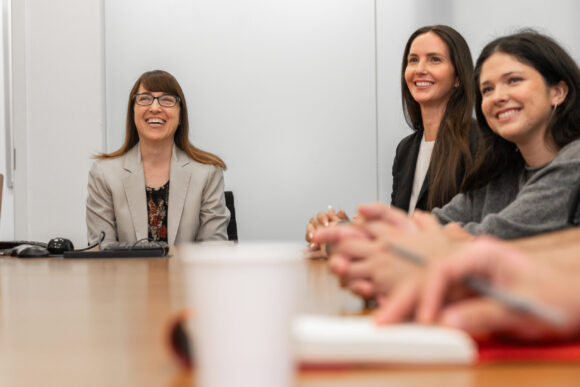 Ann Gordon, Ashley Wendell Kranjac, and Charlotte Iribarren sit at a conference table during a meeting with Team Fear researchers.